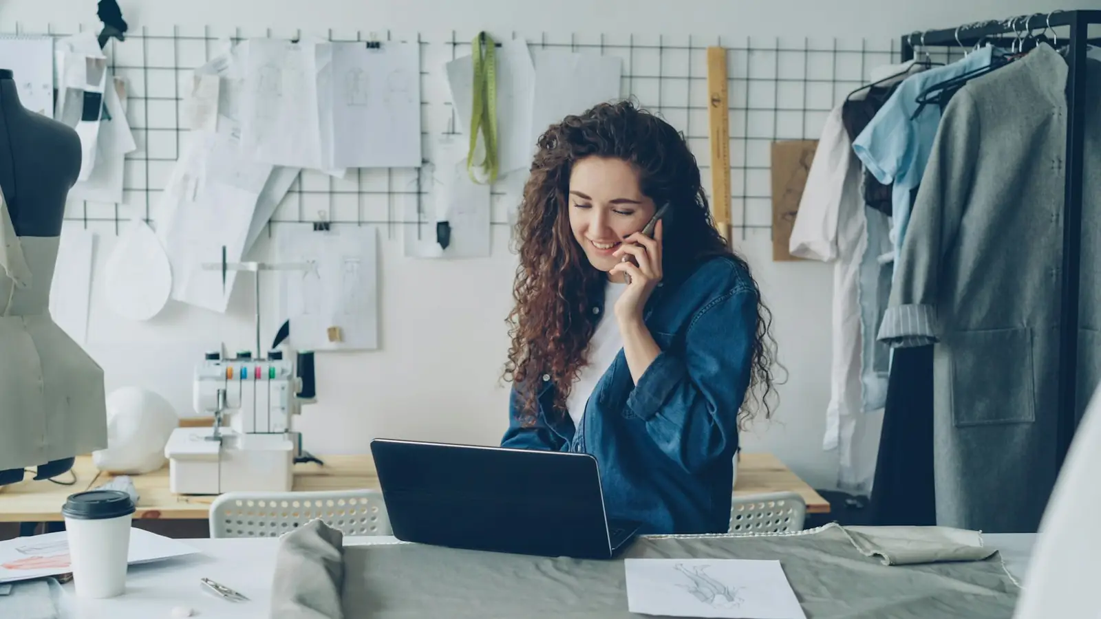 Entrepreneuse qui lance son activité, au téléphone devant son ordinateur